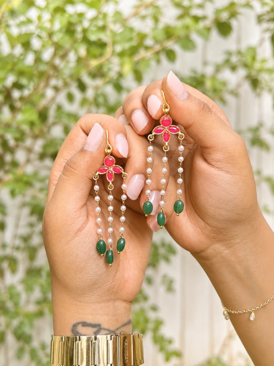Kundan and pearl earrings held in hand